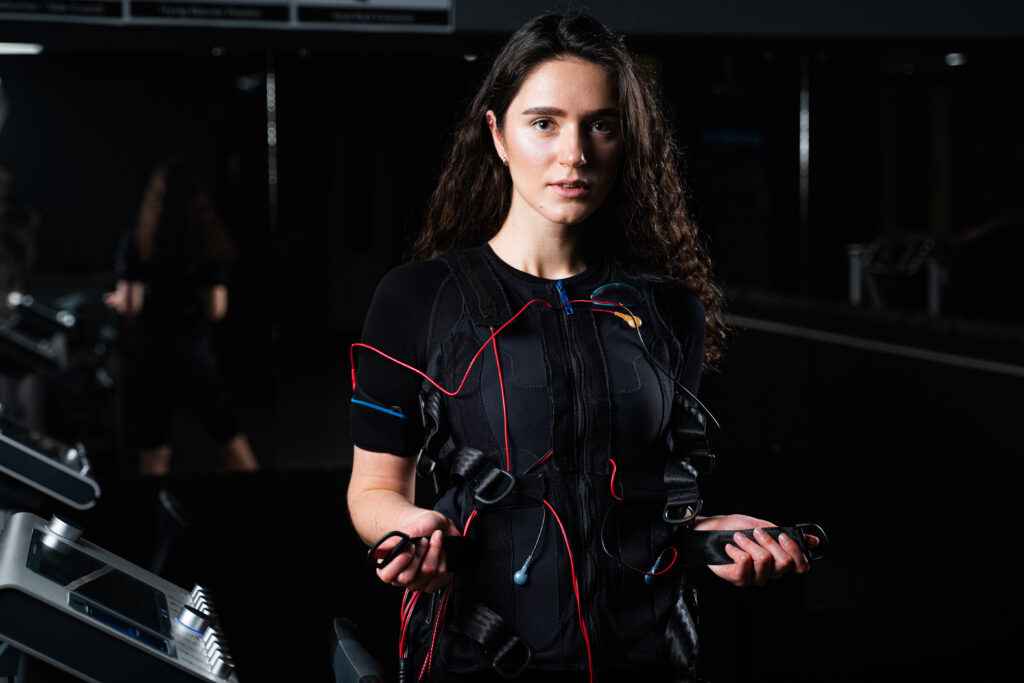 Woman performing EMS fitness exercises during gym.
