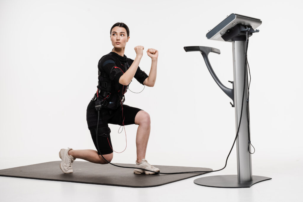 Woman doing lunges during an EMS training session, demonstrating the leg strength gains behind the does EMS build muscle research